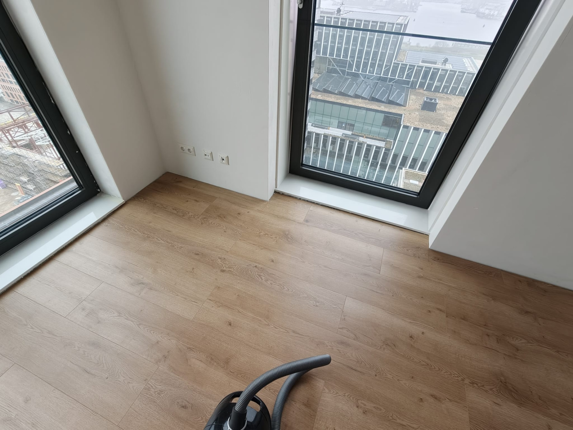 Slaapkamer met nieuwe houten vloer en grote raampartijen